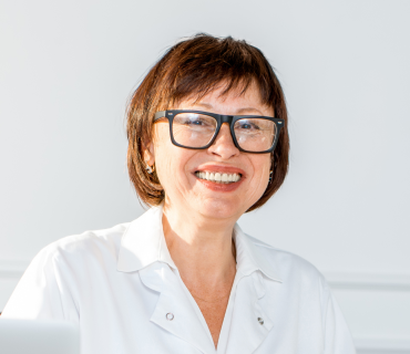 Ärztin mit einem netten lächeln schaut in die Kammera