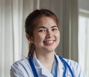 Ärztin mit einem netten lächeln schaut in die Kammera