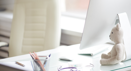 ein weißer Schreibtisch mit Monitor, Maus , Tastatur und einem Teddybären